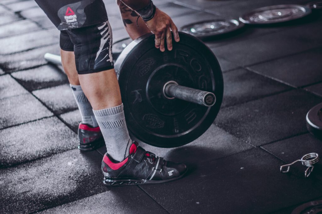 A man with a barbell, wearing weightlifting shoes
