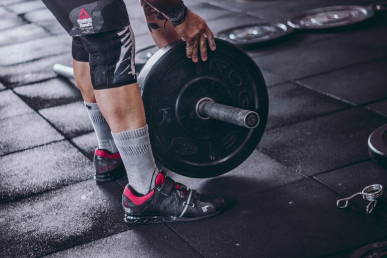A man with a barbell, wearing weightlifting shoes