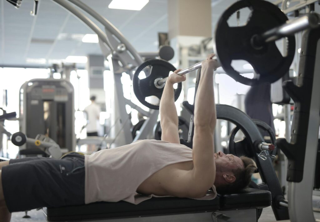 Man bench pressing alone in a gym without a spotter