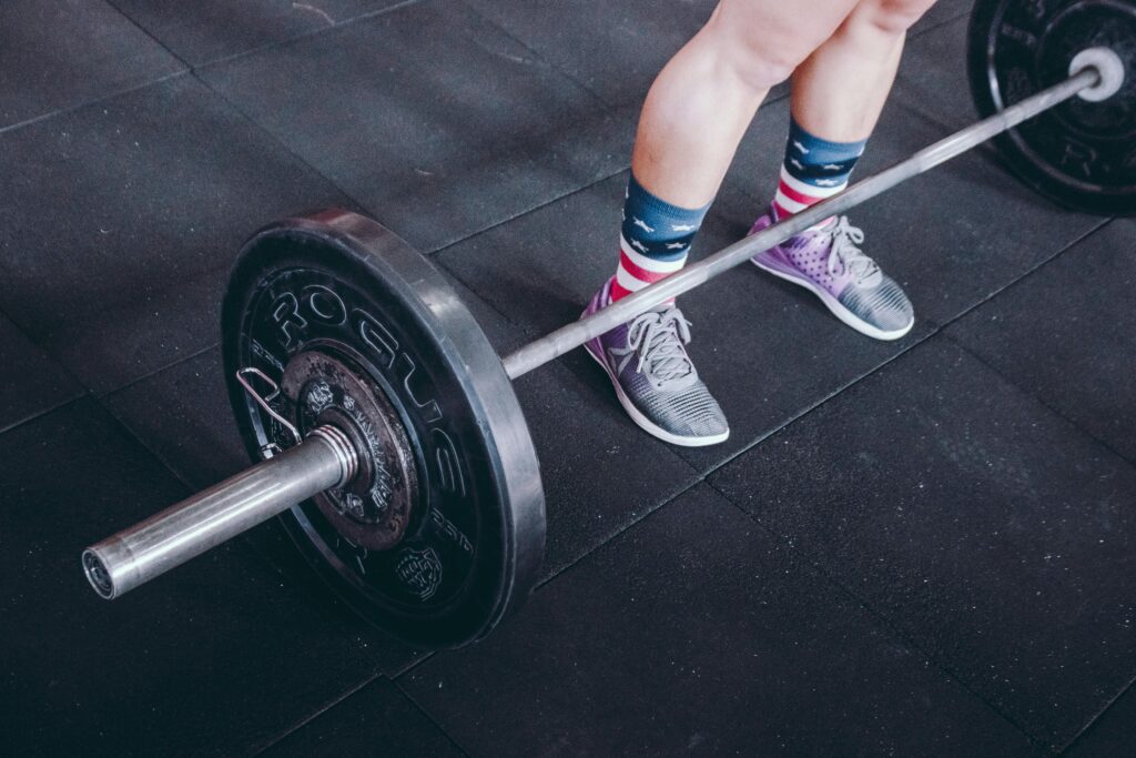 Lifter wearing the best type of deadlift shoes — flat and stable — positioned over a loaded barbell