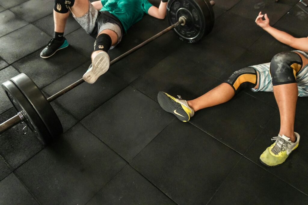 Two people resting between sets during a gym workout