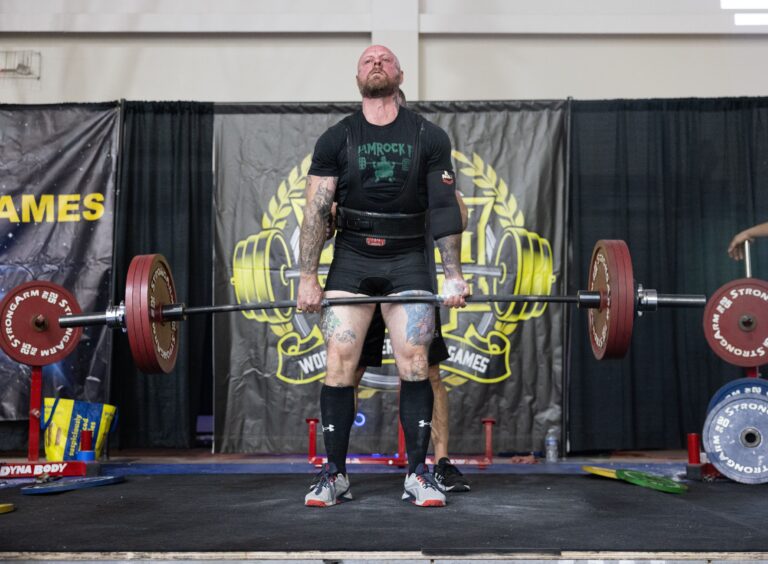 Athlete performing a conventional deadlift at a strength competition