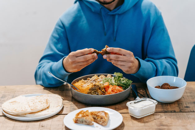 man eating a large meal to support a calorie surplus