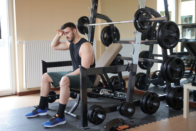 tired lifter resting on a gym bench after a hard training session